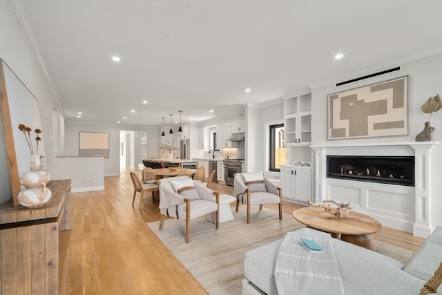 832 E 3rd Unit A, Boston, MA 02127 - living room featuring crown molding, light wood finished floors, recessed lighting, a fireplace, and built in shelves