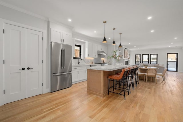 832 E 3rd Unit A, Boston, MA 02127 - kitchen with stainless steel appliances, under cabinet range hood, recessed lighting, a breakfast bar, and light wood-type flooring