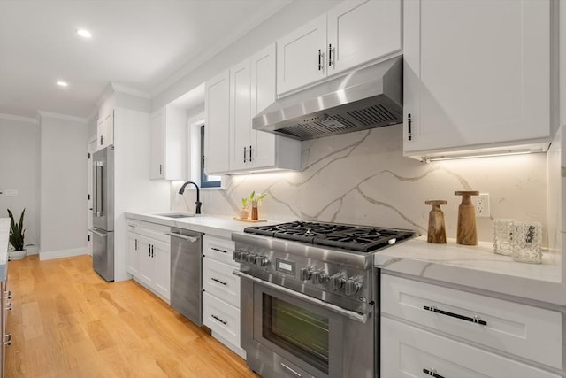 832 E 3rd Unit A, Boston, MA 02127 - kitchen featuring appliances with stainless steel finishes, under cabinet range hood, crown molding, light stone countertops, and tasteful backsplash