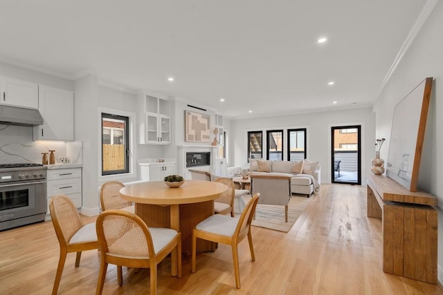 832 E 3rd Unit A, Boston, MA 02127 - dining area with crown molding, light wood-style flooring, recessed lighting, and a glass covered fireplace