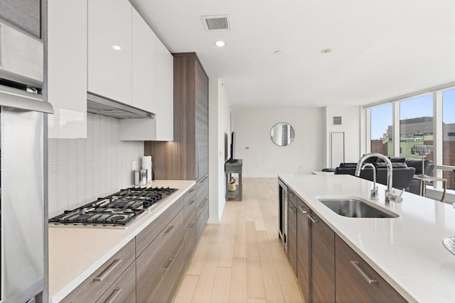 1 Franklin St Unit 1504, Boston, MA 02110 - kitchen with a sink, open floor plan, stainless steel appliances, white cabinets, and light countertops