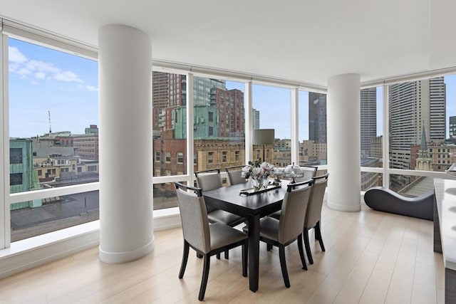 1 Franklin St Unit 1504, Boston, MA 02110 - dining space featuring a city view, wood finished floors, ornate columns, and expansive windows