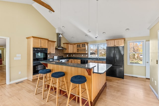 kitchen with black appliances, tasteful backsplash, pendant lighting, wall chimney exhaust hood, and light wood-type flooring