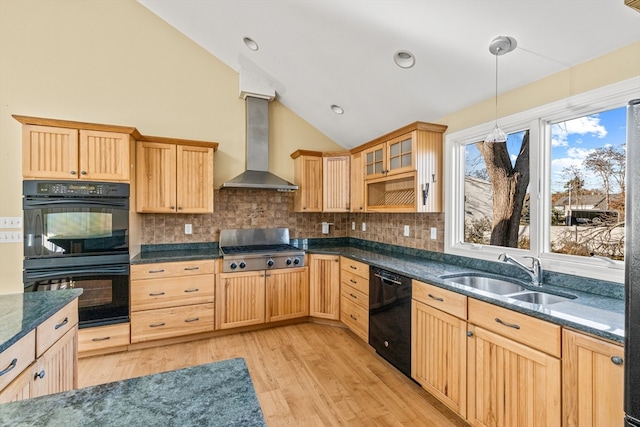 kitchen with black appliances, wall chimney range hood, sink, vaulted ceiling, and light hardwood / wood-style floors