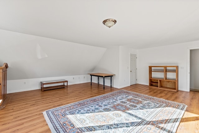 additional living space with vaulted ceiling and light hardwood / wood-style floors