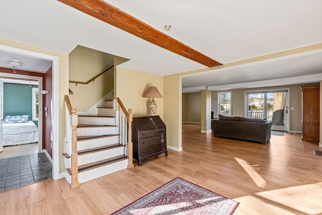 staircase with beamed ceiling and wood-type flooring