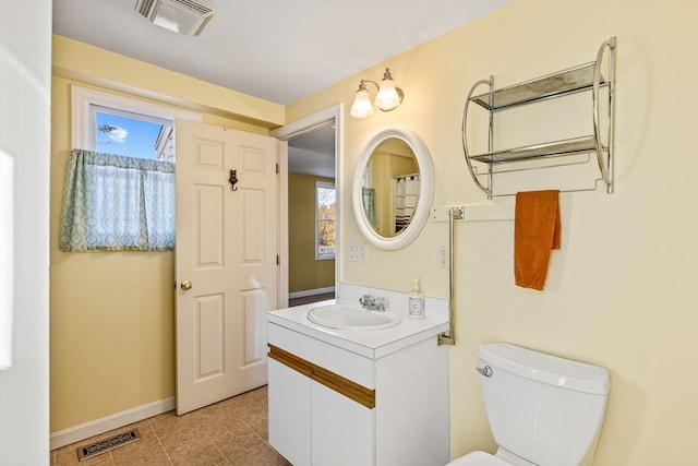 bathroom featuring toilet, vanity, and tile patterned flooring