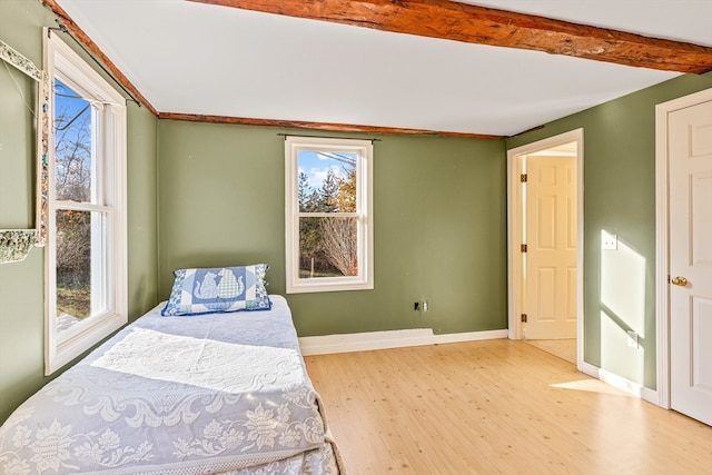 bedroom with wood-type flooring and beamed ceiling