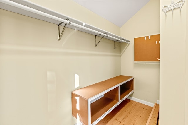 spacious closet with light hardwood / wood-style flooring and vaulted ceiling