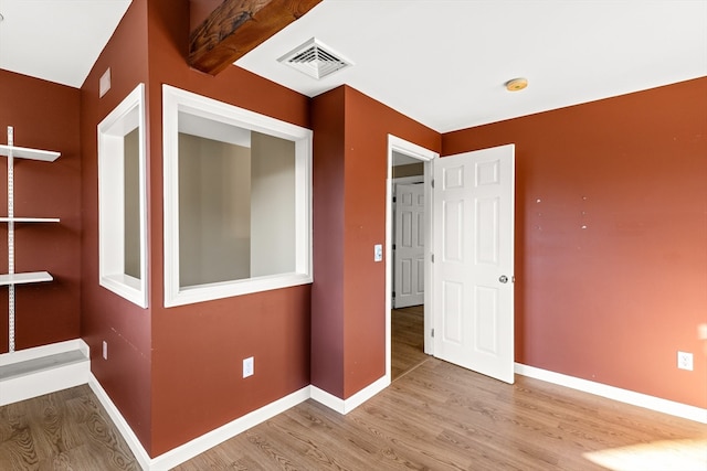 hallway with beamed ceiling and light wood-type flooring