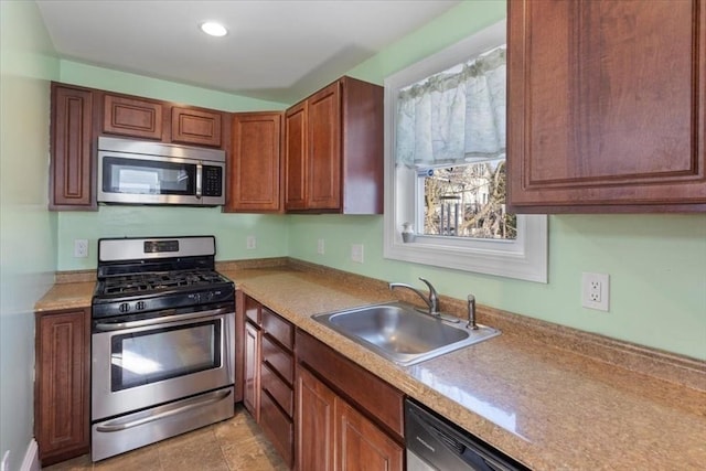 kitchen with stainless steel appliances, sink, and light tile patterned floors