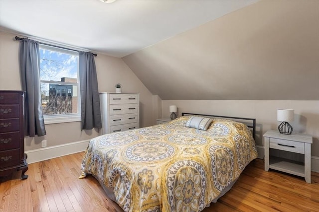 bedroom featuring lofted ceiling and wood-type flooring