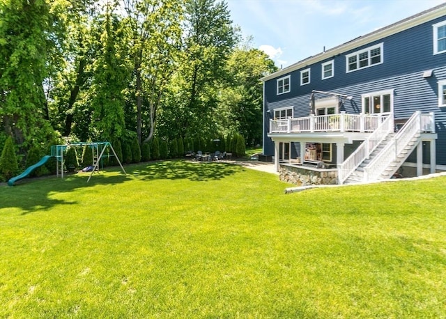 17 Elinor Cir, Waltham, MA 02452 - back of property with a wooden deck, a patio area, a lawn, stairs, and a playground