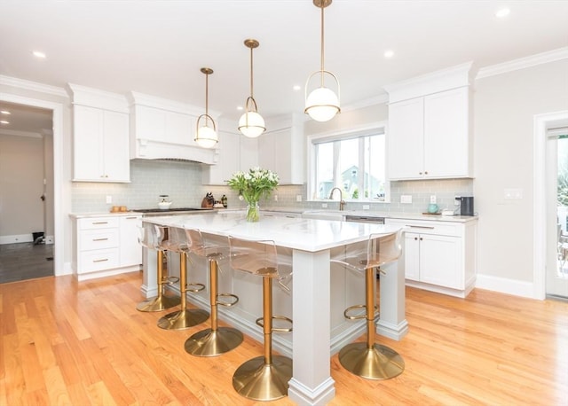 17 Elinor Cir, Waltham, MA 02452 - kitchen featuring light countertops, white cabinets, light wood-style floors, a kitchen island, and tasteful backsplash