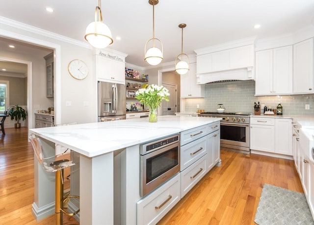 17 Elinor Cir, Waltham, MA 02452 - kitchen featuring appliances with stainless steel finishes, open shelves, a center island, light wood-style floors, and white cabinets