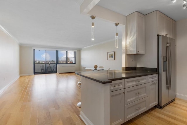 8 Whittier Pl Unit 15A, Boston, MA 02114 - kitchen with stainless steel fridge, dark countertops, crown molding, open floor plan, and light wood-style floors