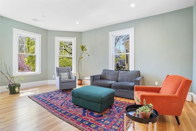 living area with baseboards, recessed lighting, and wood finished floors