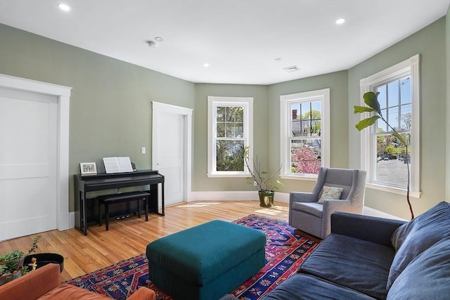 living area with recessed lighting, visible vents, and light wood-style flooring