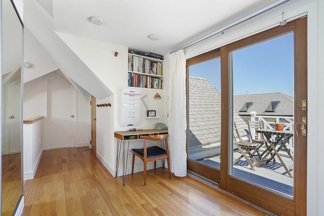 doorway featuring baseboards, light wood-style flooring, and a wealth of natural light