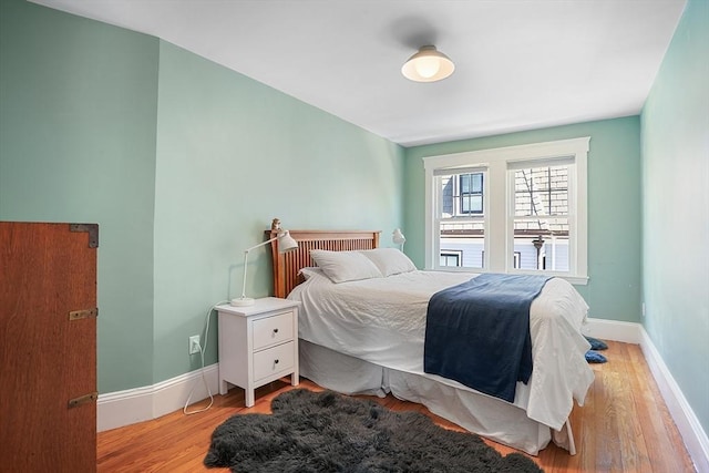 bedroom with baseboards and light wood-style flooring