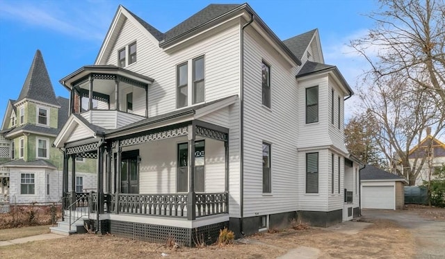 victorian-style house with an outbuilding, a porch, and a garage