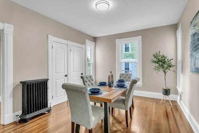 dining area with wood-type flooring and radiator