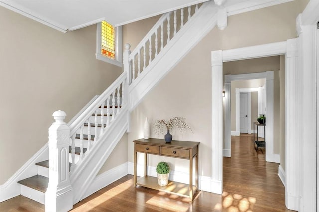 stairs featuring hardwood / wood-style floors and crown molding