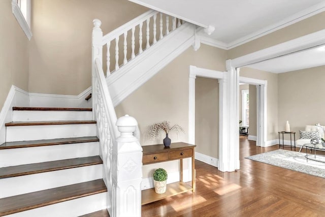 stairs with hardwood / wood-style floors and ornamental molding