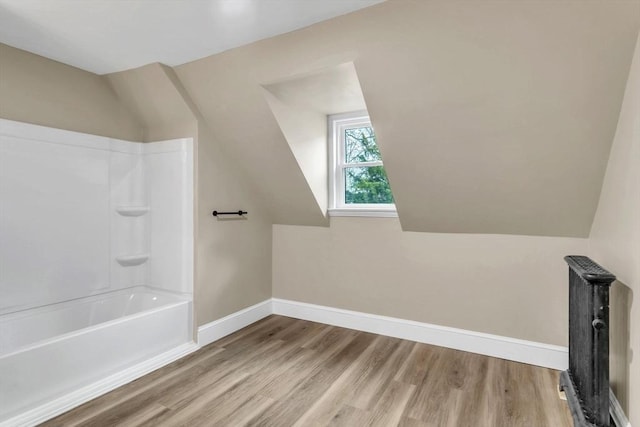 bathroom featuring hardwood / wood-style floors and  shower combination