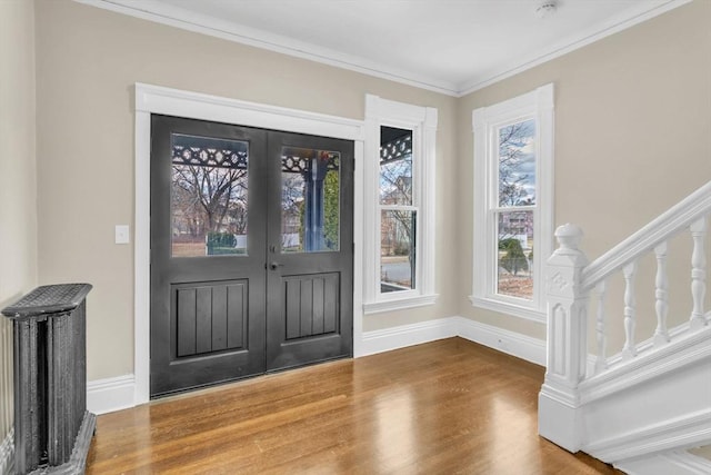 foyer featuring hardwood / wood-style floors, ornamental molding, and french doors