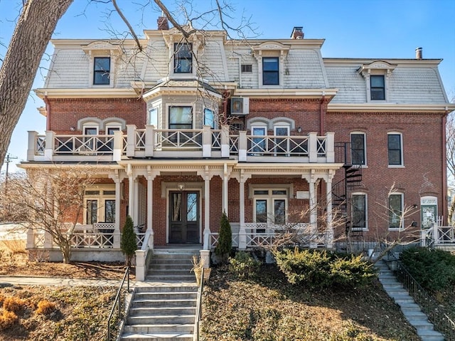 second empire-style home with stairs, a high end roof, brick siding, and mansard roof