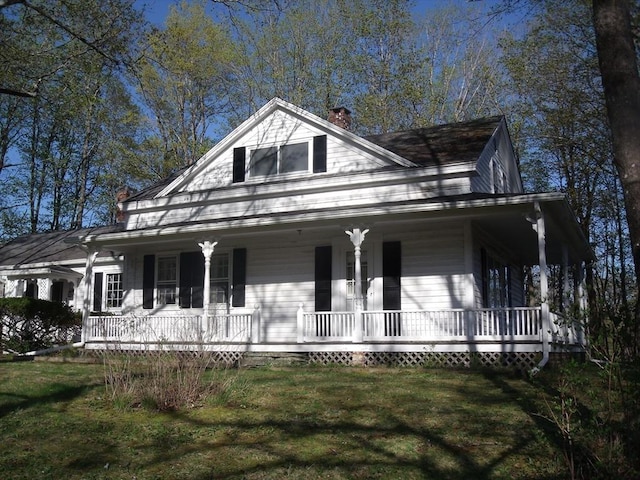 2 N St, Williamsburg, MA 01096 - farmhouse-style home featuring covered porch, a chimney, and a front lawn