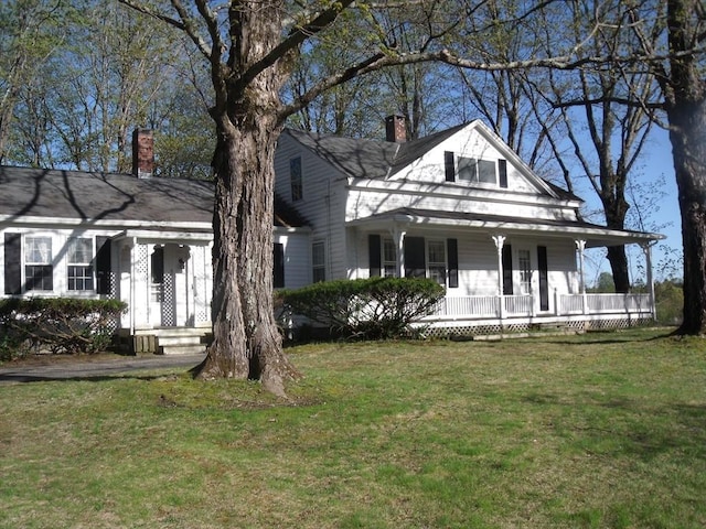 2 N St, Williamsburg, MA 01096 - view of front facade featuring covered porch, a chimney, and a front lawn