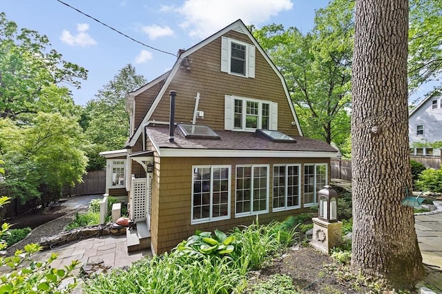26 Saxon Rd, Newton, MA 02461 - rear view of property featuring a gambrel roof, a shingled roof, and a patio