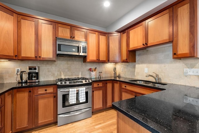 10 Peters Unit 2, Boston, MA 02127 - kitchen with stainless steel appliances, a sink, brown cabinetry, dark stone counters, and tasteful backsplash