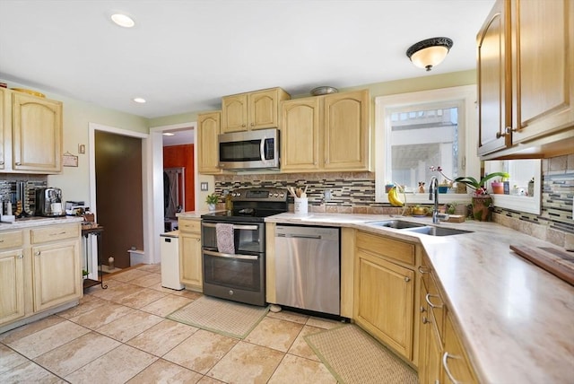 kitchen with sink, decorative backsplash, stainless steel appliances, and light tile patterned floors