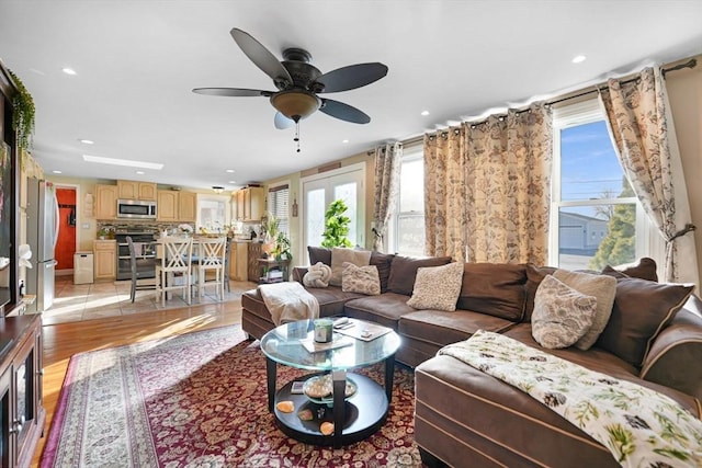 living room with ceiling fan and light hardwood / wood-style floors