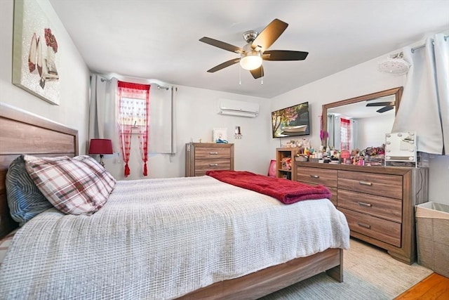 bedroom featuring ceiling fan, a wall unit AC, and light wood-type flooring