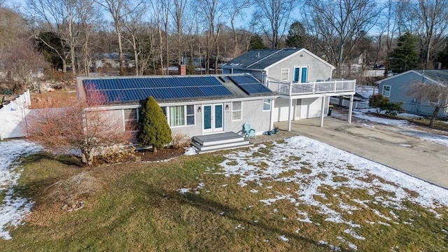 view of front of home with a garage, french doors, and solar panels