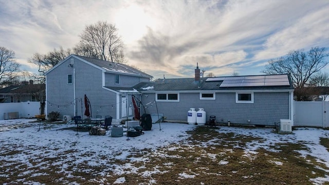 snow covered house featuring solar panels