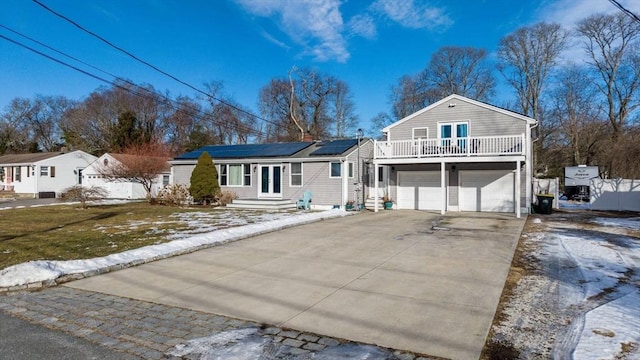 view of front of property featuring a garage, a front yard, and solar panels