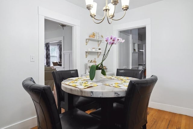 139 Washington St, Hudson, MA 01749 - dining area with a chandelier, wood finished floors, and baseboards