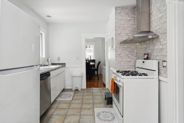 139 Washington St, Hudson, MA 01749 - kitchen featuring white appliances, wall chimney range hood, white cabinets, wainscoting, and a sink