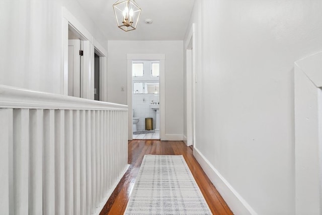 139 Washington St, Hudson, MA 01749 - hall with wood-type flooring, a chandelier, baseboards, and a sink