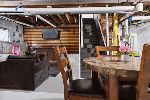 139 Washington St, Hudson, MA 01749 - dining space featuring finished concrete flooring, stairs, and wood walls
