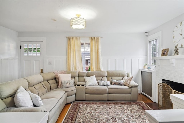 139 Washington St, Hudson, MA 01749 - living area with healthy amount of natural light, a wainscoted wall, wood finished floors, a decorative wall, and a fireplace