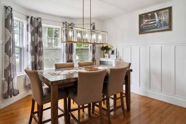 139 Washington St, Hudson, MA 01749 - dining space featuring a decorative wall, wood finished floors, wainscoting, and a chandelier