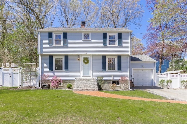 colonial home with a chimney, a gate, entry steps, an attached garage, and driveway