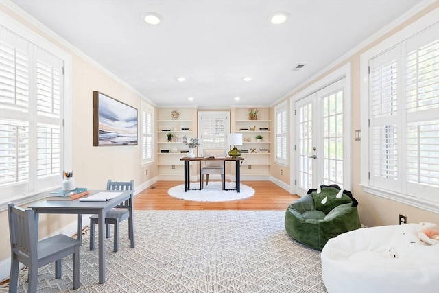 office area featuring ornamental molding, light wood-style flooring, and plenty of natural light