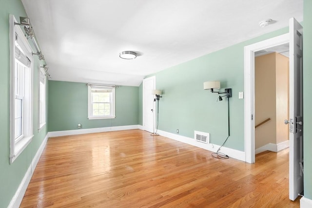 interior space featuring baseboards, light wood finished floors, and visible vents
